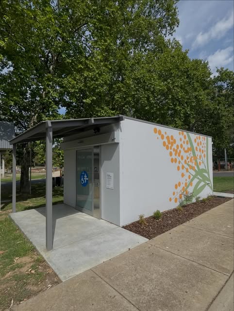 Large-format printed wattle mural wrapping a public amenities building