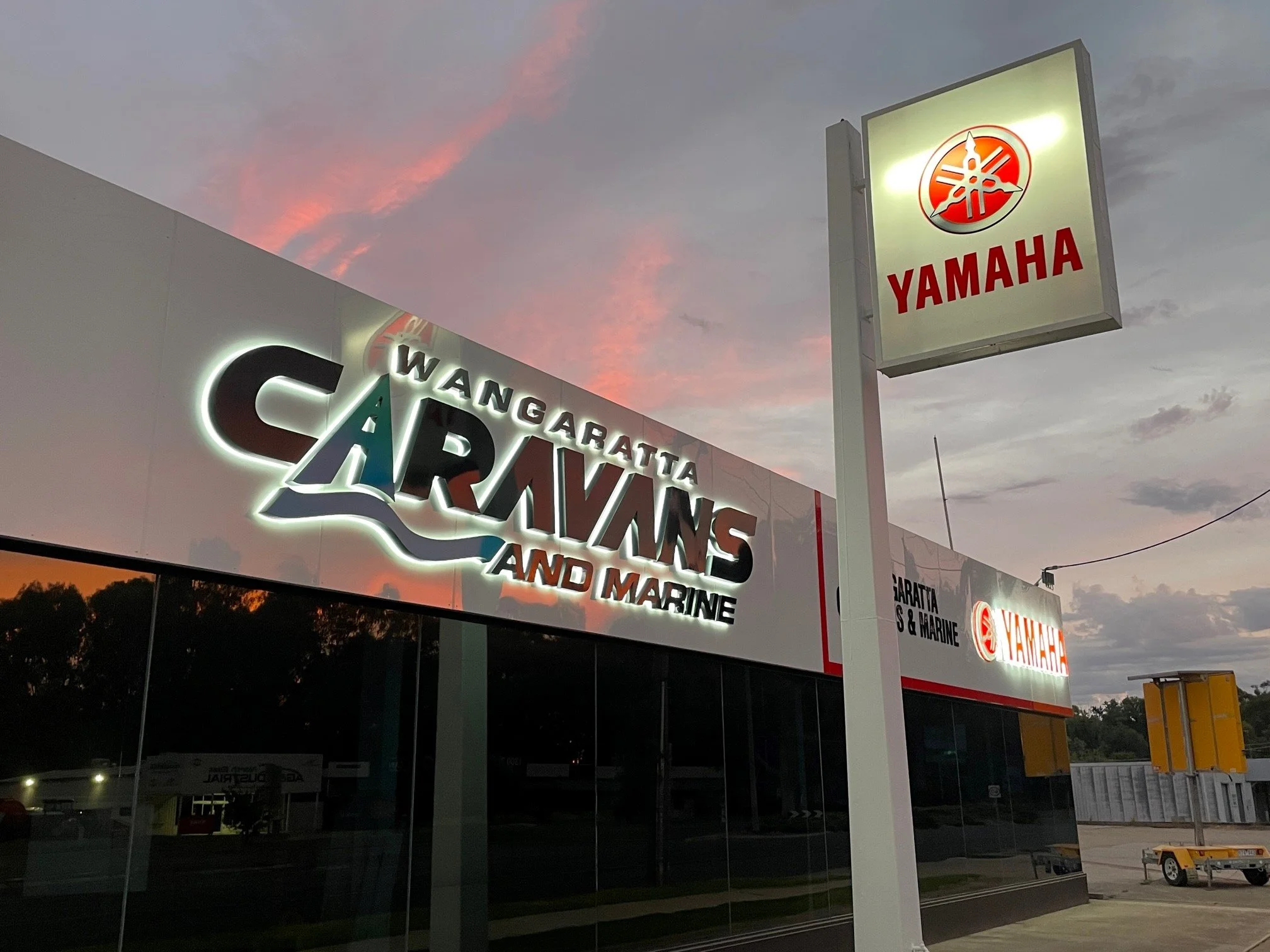 Wangaratta Caravans and Marine halo-lit fabricated lettering and Yamaha pylon at dusk